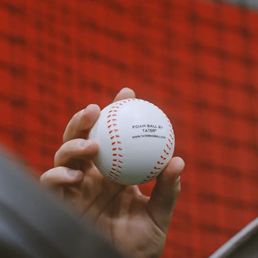 Tater 5 oz foam pitching machine baseball held in hand — Tater Baseball