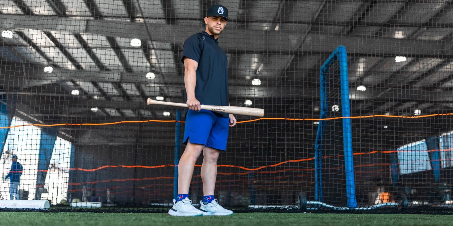 Professional Baseball Player Holding Natural Colored Maple Wood Bat inside Batting Cage in Dunedin Florida