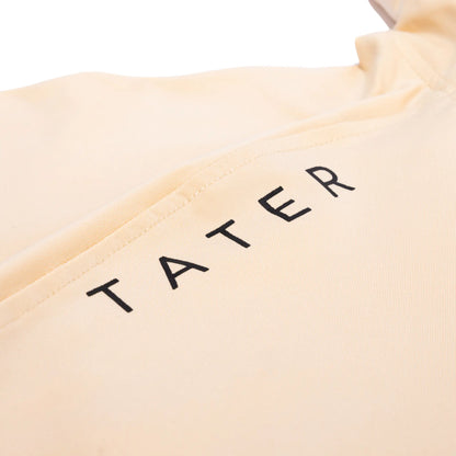 Close-up of a tan hoodie with the 'TATER' brand logo in bold black letters along the hood's edge, showcasing the brand's strong identity.