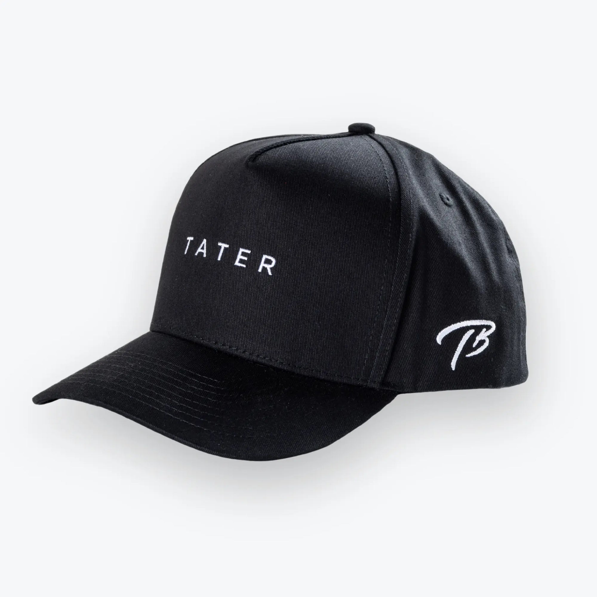 The image features a black snapback hat with the word "TATER" embroidered in white on the front, signifying the Tater Baseball brand. The side of the cap also has the Tater Baseball logo, which appears to be a stylized "TB" in white thread. The hat's design is minimalistic and contemporary, likely appealing to a wide range of customers, both within the baseball community and those interested in casual athletic wear.