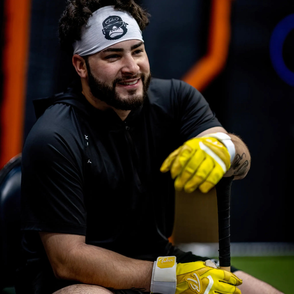 Relaxed professional baseball player wearing a Tater headband, featuring the Tater Kong logo, complemented by striking yellow Tater batting gloves, ready for action.